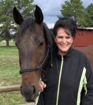 A striking woman with dark hair standing next to a horse